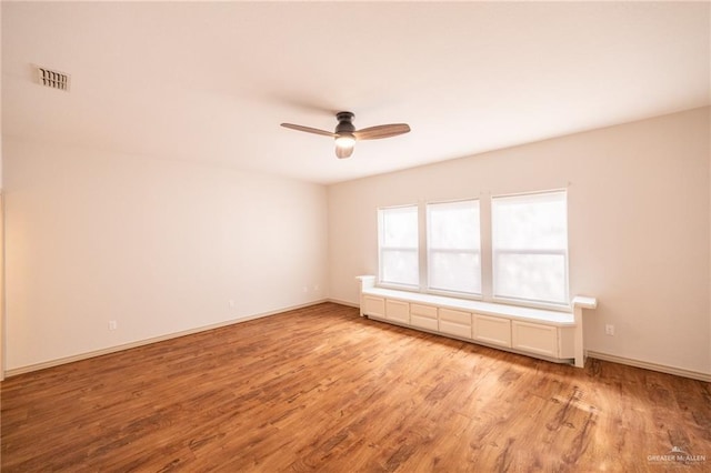 empty room with ceiling fan and light wood-type flooring