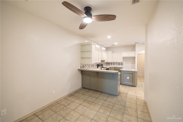 kitchen featuring decorative backsplash, a kitchen bar, kitchen peninsula, white cabinets, and stainless steel electric range oven