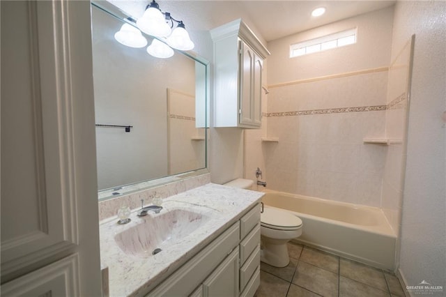 full bathroom with tile patterned floors, vanity, tiled shower / bath combo, a notable chandelier, and toilet