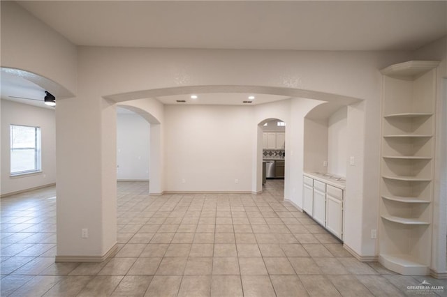 interior space with ceiling fan, white cabinetry, and light tile patterned floors