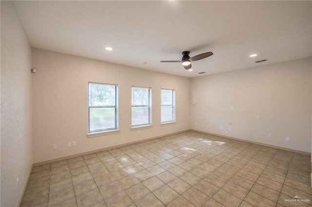 tiled empty room featuring ceiling fan