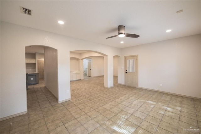 tiled empty room featuring ceiling fan