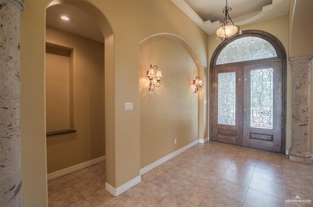 entrance foyer featuring french doors, a raised ceiling, and light tile patterned floors