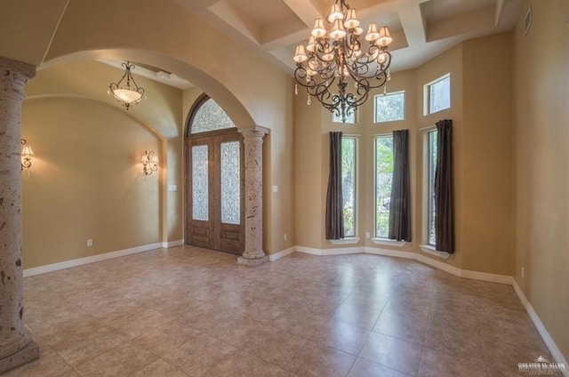 entrance foyer with coffered ceiling, french doors, beamed ceiling, and ornate columns