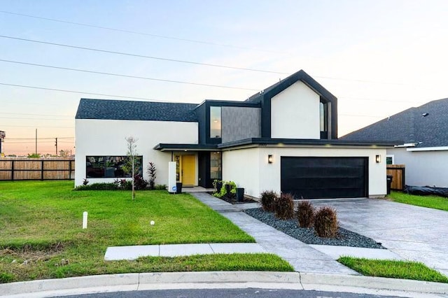 view of front of house featuring a front yard, fence, driveway, and stucco siding