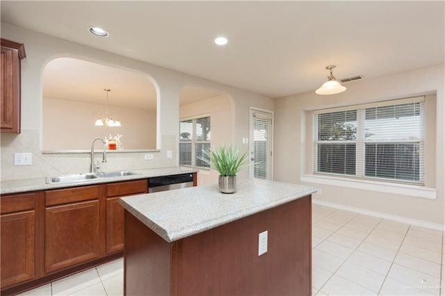 kitchen featuring pendant lighting, a center island, sink, stainless steel dishwasher, and a notable chandelier