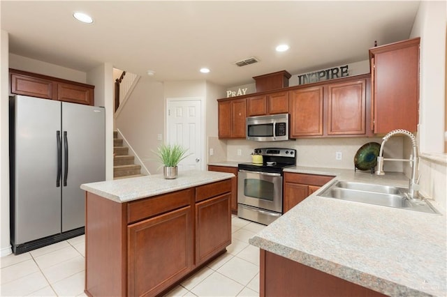 kitchen featuring sink, a center island, stainless steel appliances, and light tile patterned floors