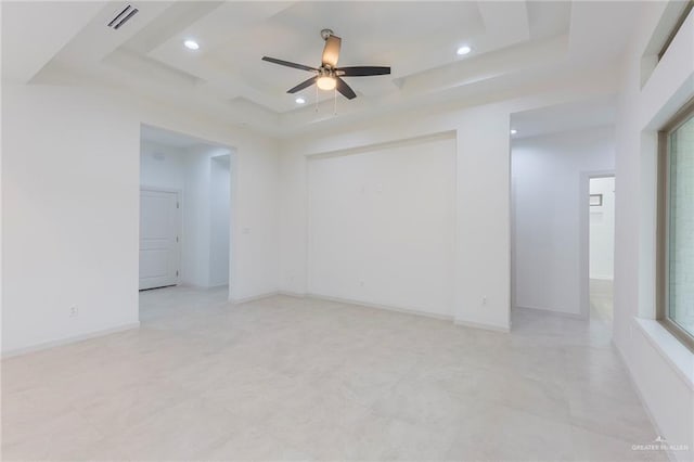 spare room featuring a raised ceiling and ceiling fan