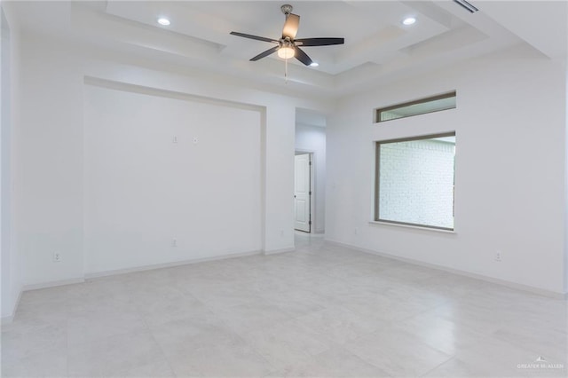 spare room with a raised ceiling and ceiling fan