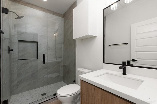 bathroom featuring walk in shower, vanity, and toilet