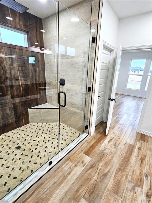 bathroom featuring hardwood / wood-style flooring and a shower with shower door