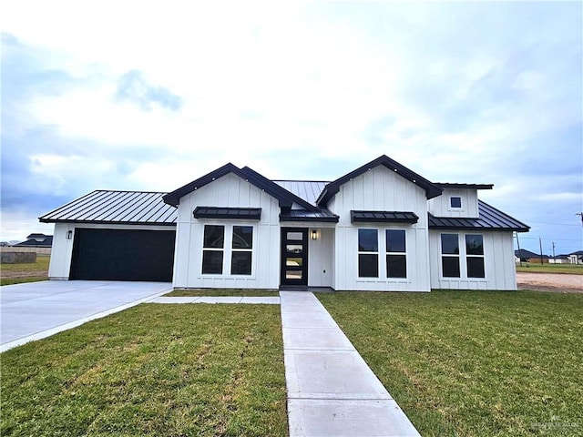 modern inspired farmhouse with a front yard and a garage