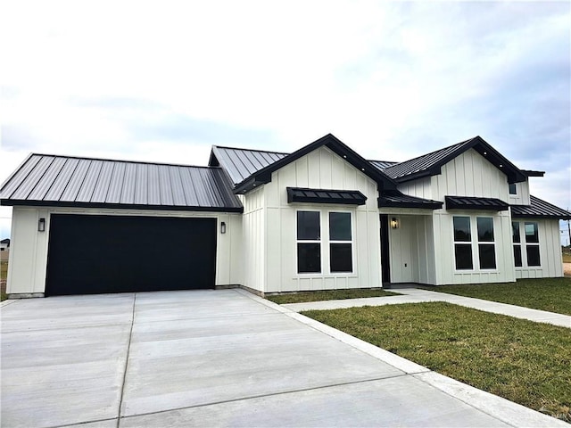 modern inspired farmhouse featuring a garage and a front lawn