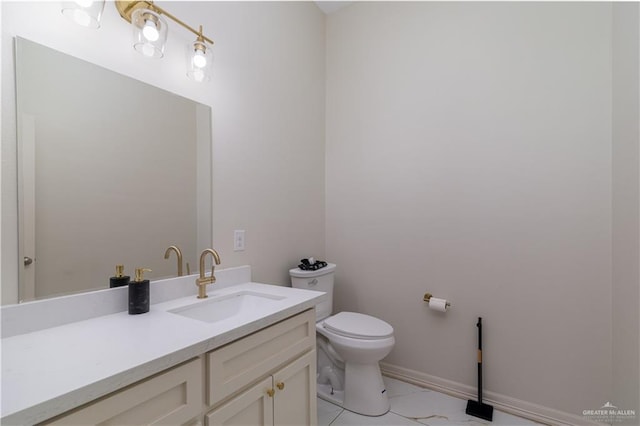 half bathroom featuring vanity, toilet, and baseboards
