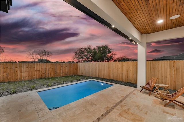 pool at dusk featuring a patio area