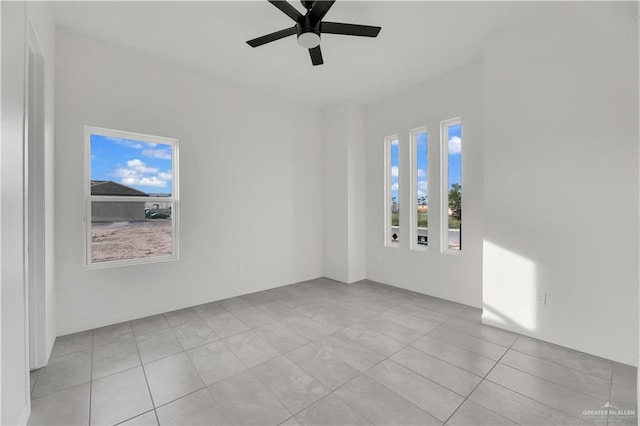 tiled spare room with ceiling fan