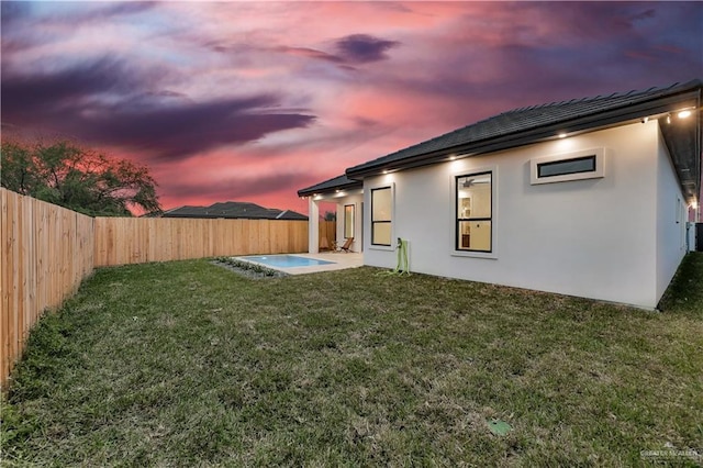 yard at dusk featuring a patio area