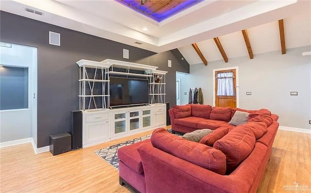 living area with vaulted ceiling with beams, light wood-style flooring, visible vents, and baseboards