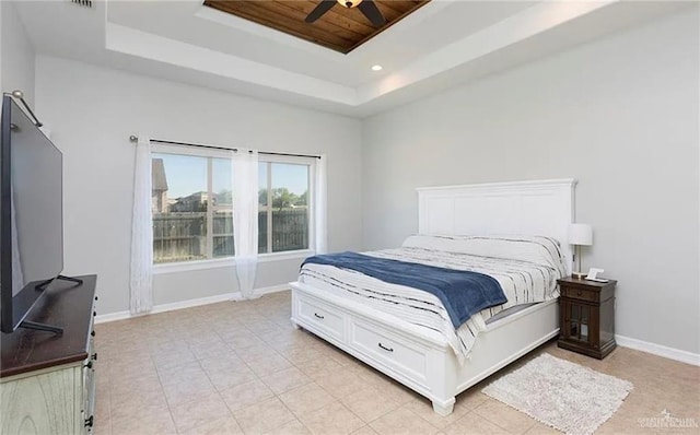 bedroom with light tile patterned floors, baseboards, a tray ceiling, and recessed lighting