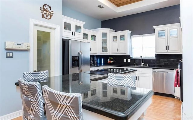 kitchen featuring appliances with stainless steel finishes, white cabinets, and a sink