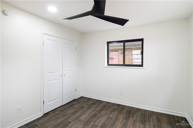 unfurnished bedroom with wood finish floors, a closet, baseboards, and ceiling fan