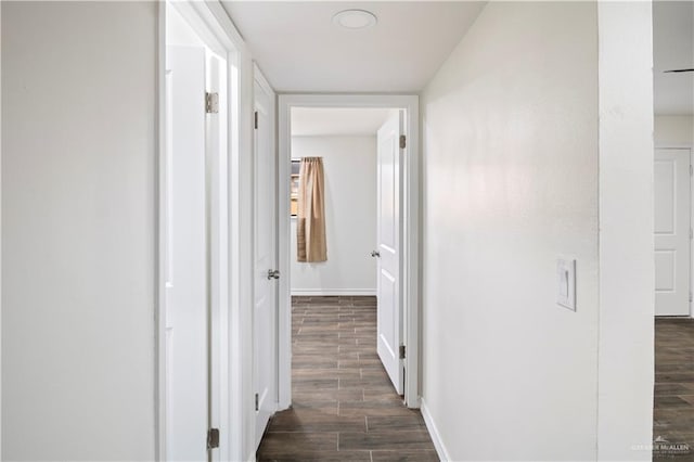 corridor featuring wood finish floors and baseboards