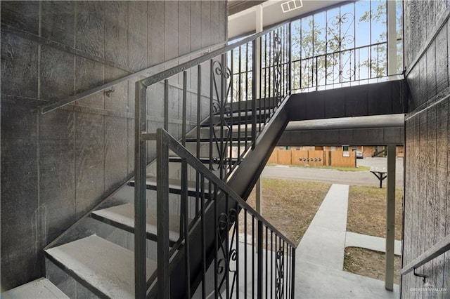 stairway featuring visible vents and a high ceiling