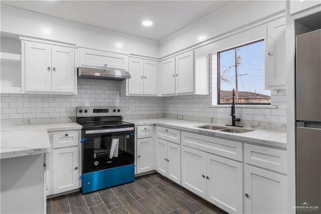 kitchen featuring wood finish floors, under cabinet range hood, a sink, appliances with stainless steel finishes, and white cabinets