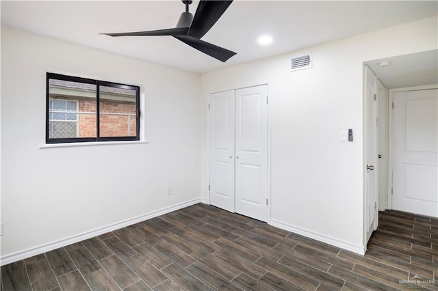 unfurnished bedroom with a closet, baseboards, visible vents, and wood tiled floor