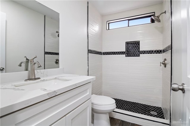 full bath featuring toilet, a stall shower, and vanity