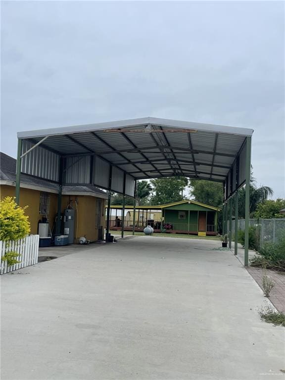 view of car parking with electric water heater and a carport