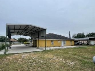 view of side of home featuring a carport and a lawn