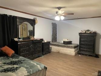 bedroom featuring ceiling fan, wood-type flooring, and crown molding