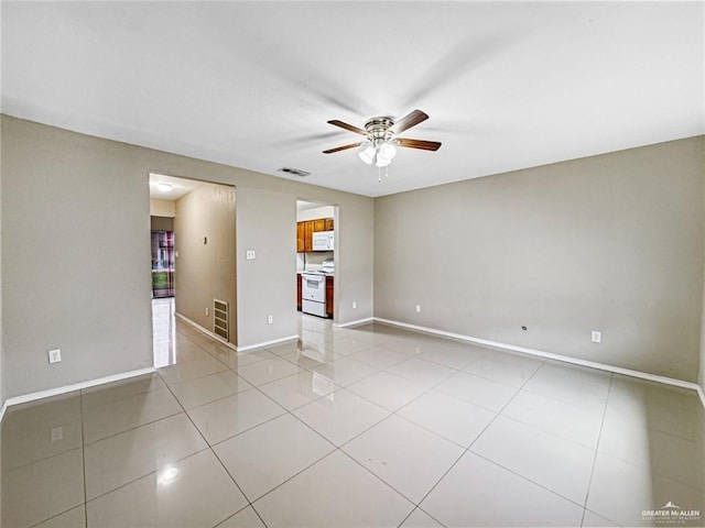 tiled spare room with ceiling fan