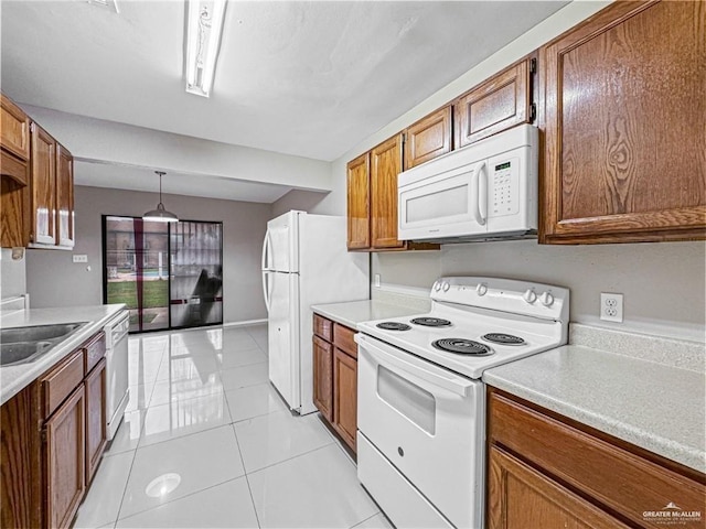 kitchen with white appliances, light tile patterned flooring, pendant lighting, and sink