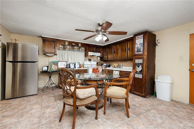 kitchen featuring stainless steel fridge, dark brown cabinetry, white range, and ceiling fan