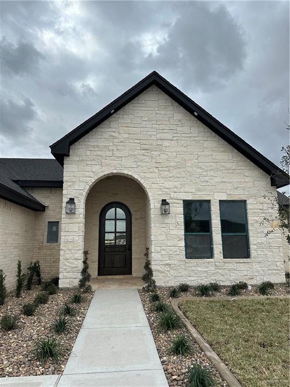 view of exterior entry featuring a shingled roof