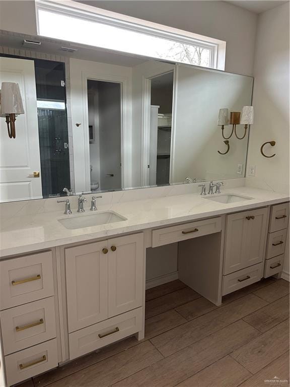 full bathroom featuring double vanity, a sink, and wood finished floors