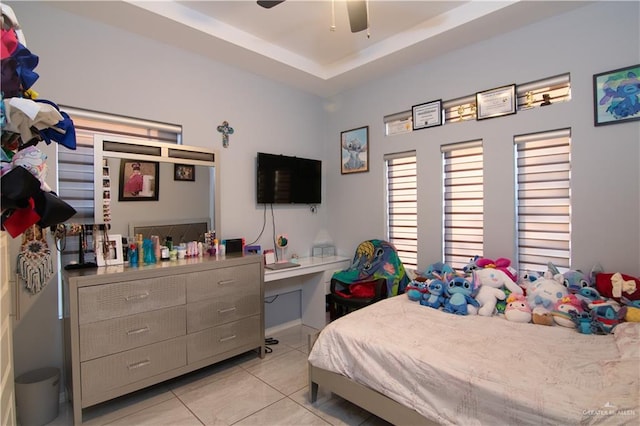 bedroom featuring a tray ceiling, ceiling fan, and light tile patterned floors