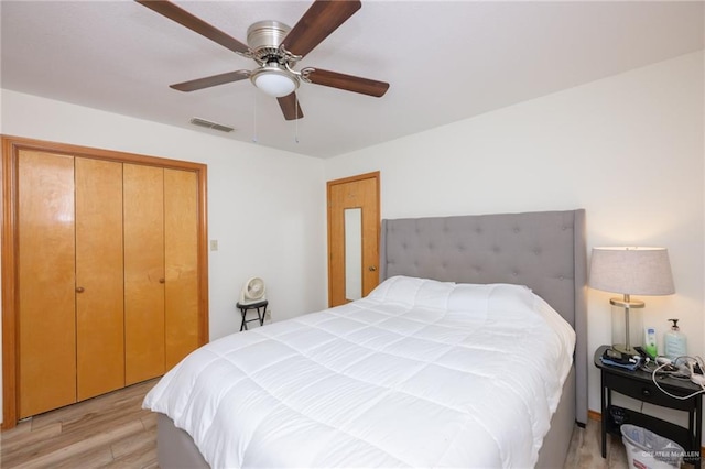 bedroom with light hardwood / wood-style floors, a closet, and ceiling fan