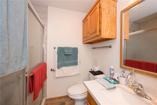 bathroom with toilet, vanity, hardwood / wood-style floors, and walk in shower