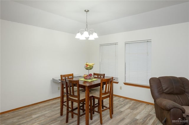 dining area featuring light hardwood / wood-style floors and an inviting chandelier