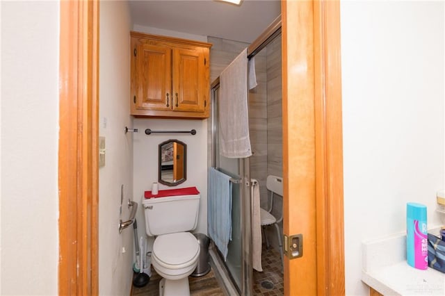 bathroom featuring toilet and a shower with door