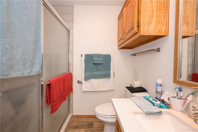 bathroom featuring hardwood / wood-style floors, vanity, toilet, and walk in shower