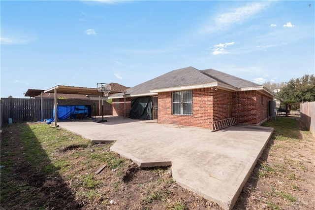 rear view of house with a patio area, a fenced backyard, a yard, and brick siding