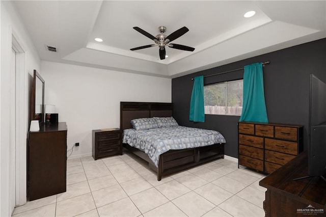 bedroom featuring light tile patterned floors, ceiling fan, and a tray ceiling