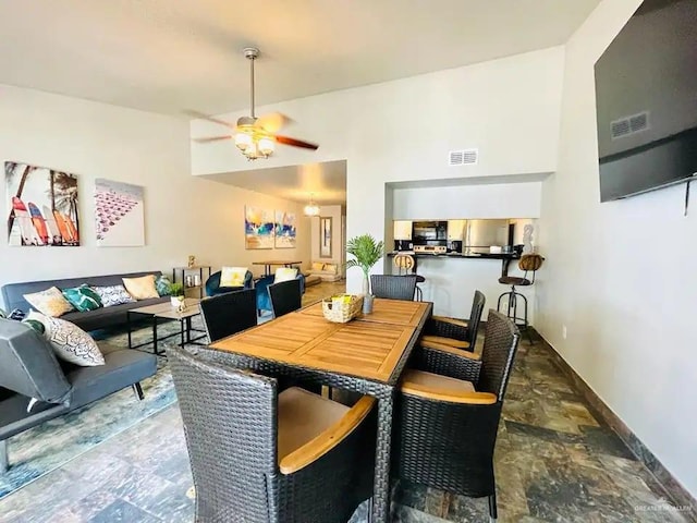 117B E Mezquite St, South Padre Island, TX 78597 - dining area featuring a ceiling fan, baseboards, and a high ceiling