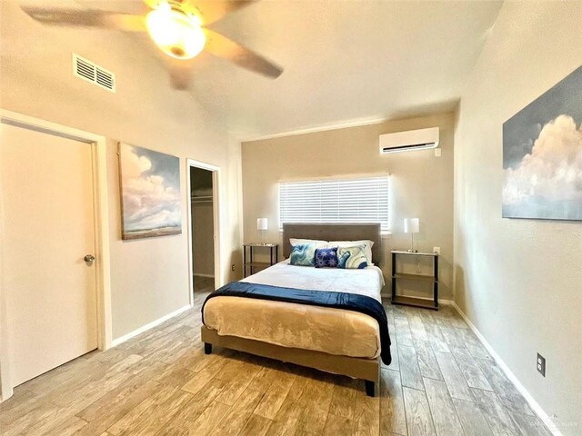 117B E Mezquite St, South Padre Island, TX 78597 - bedroom with a wall mounted AC, wood finished floors, ceiling fan, and baseboards