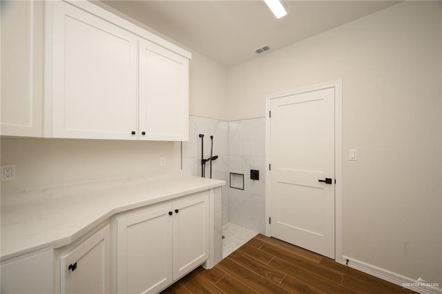 washroom with cabinets and dark wood-type flooring