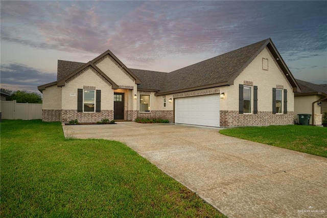 view of front of home with a garage and a yard